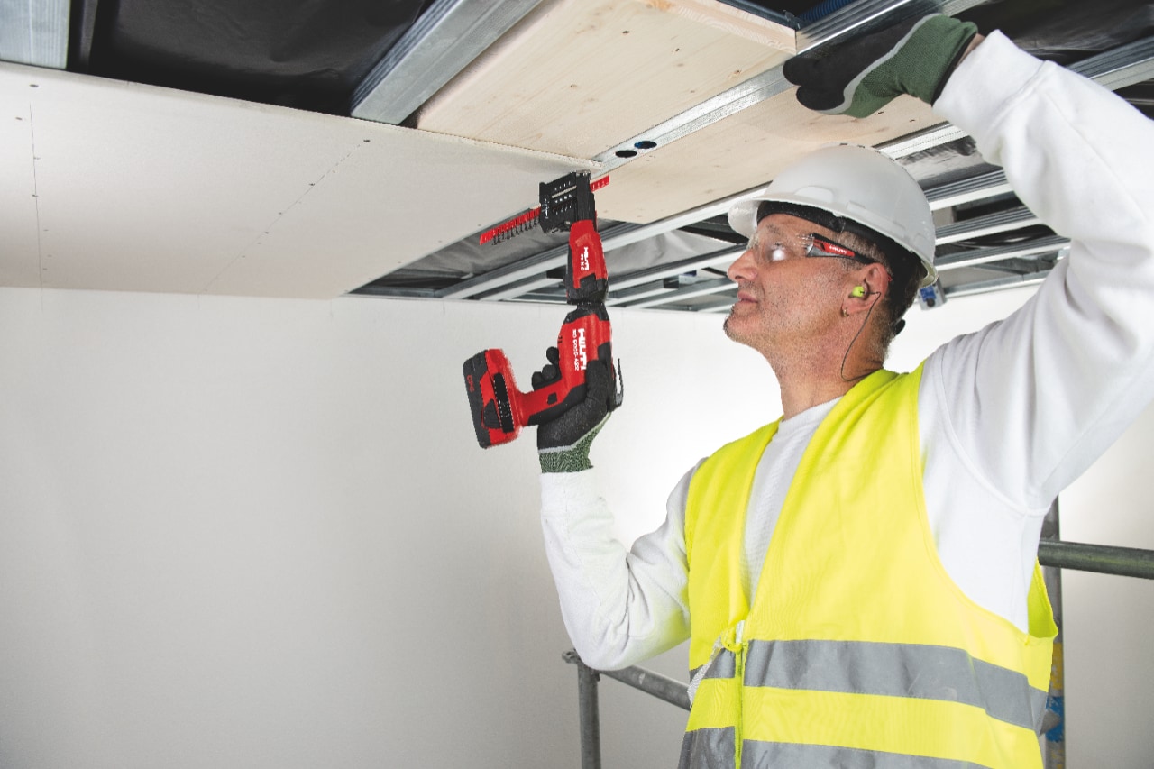 Image of drywall being installed overhead using collated screws, a screw magazine and the new SD 5000-A22 cordless drywall screwdriver